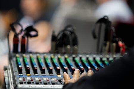 Sound engineer is controlling sound mixer board in concert event.の写真素材