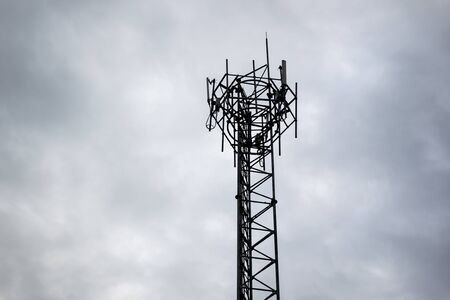 Shadow of telecommunication tower in the dark cloud sky.