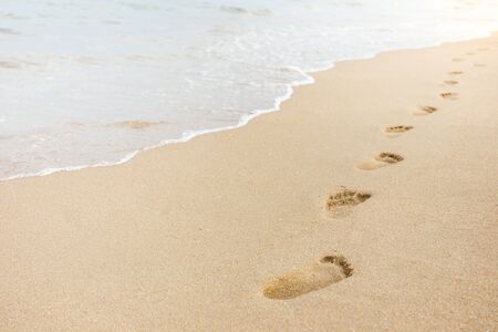 Foot print on sand at the beach backgroundの写真素材