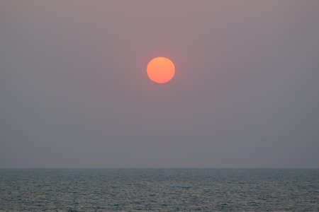 Landscape of the big sun over the sea close up.の写真素材