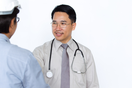 Photograph of doctor and engineer meeting and shakehand on solid white background.の写真素材