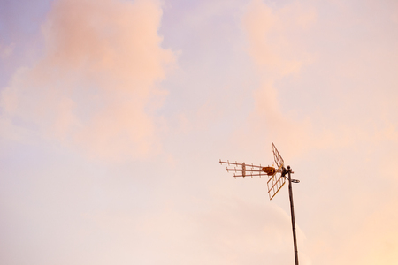 Old small antenna on the beautiful sky in evening before the sunset.の写真素材