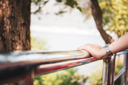 Woman left her hands on the stainless rail at balcony to relax.の写真素材