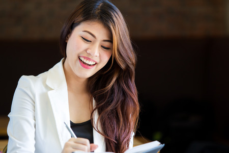Business women writing something on her notebook close up.の写真素材