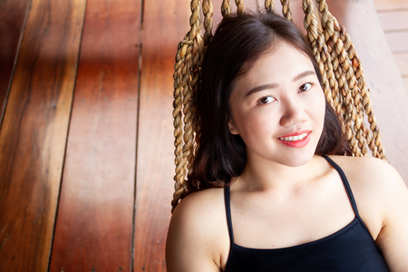 Portrait of a beautiful Asian women laying her body on a hammock smilingの写真素材