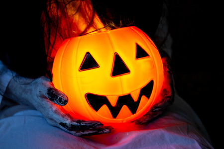 Illumination halloween pumpkin with a monster in white dress close up.の写真素材