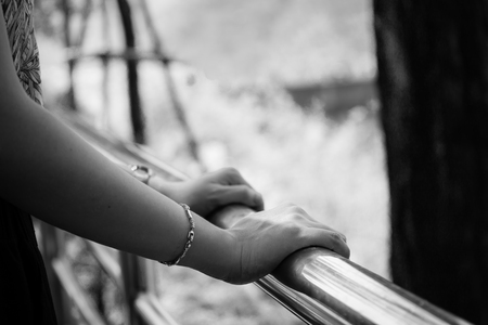 Women standing and resting beside the stainless fence with natural blurred background.  Processed in Black and White color tone.の写真素材