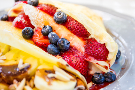 Multi berry crape and banana with chocolate sauce close up.の写真素材