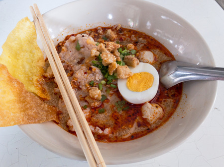 Thai Tom Yum Spicy Noodle with the boiled eeg close up.の写真素材