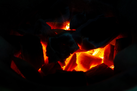 Black chacoal fire wood burning in a stove close up.の写真素材