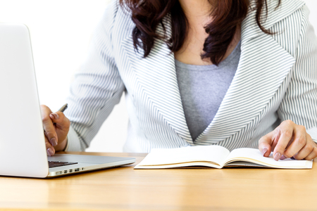 Smart young Asian business women age between 25-30 years old smiling and using a laptop computer close up.  Concept of smart and confident women in business.の写真素材