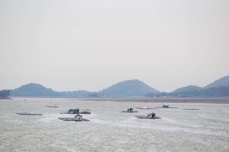 Landscape of the fishery farm in the natural lake during the cloudy day.