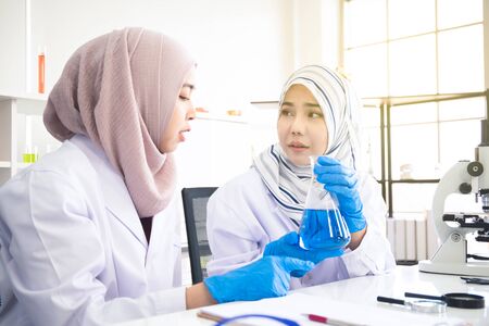 Two Muslim woman chemical scientist doing the experiment in laboratory.の写真素材