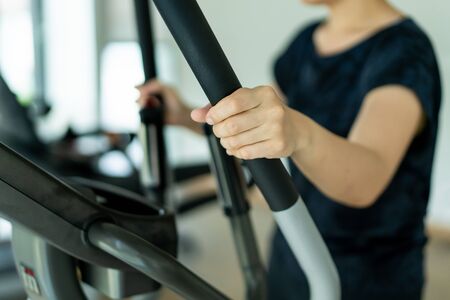 Asian fat woman using exercise machines in indoor gym, sport Asian woman's portrait with copy space.