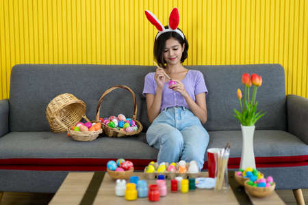 Asian young pretty woman enjoy taking a photo to the colorful fantasy Easter egg by using...