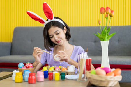 Asian young pretty woman enjoy painting a water colors on fantasy eggs for Easter egg festival....