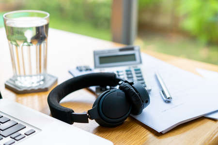 Modern stereo wireless headphones left on the laptop computer with copy space on left side close up....