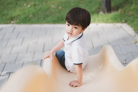 Asian happy little boy enjoy playing at playground, happy little boy playing a slider at playground. Body exercise in young children.の写真素材