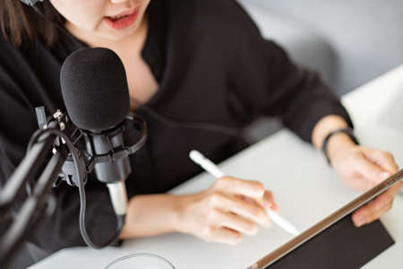 Beautiful and good looking young Asian woman arranging home podcast channel. Businesswoman recording...