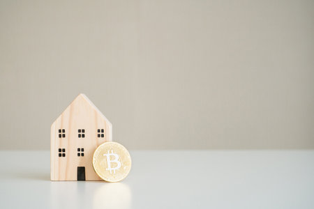 Concept of Bitcoin - BTC and mock up wooden house model means that using Bitcoin or cryptocurrency for purchasing and investment.の写真素材