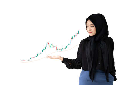 Beautiful Asian young muslim woman standing on the bright yellow background and showing right hand on the space for text in copy space. Satisfaction and trust concept. Diversity business formal.の写真素材