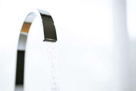 Water flowing from the luxury water tap in wash room with copyspaceの写真素材