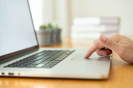 Unrecognizable businessman using a fingers on a touchpad or trackpad of laptop computer close up...