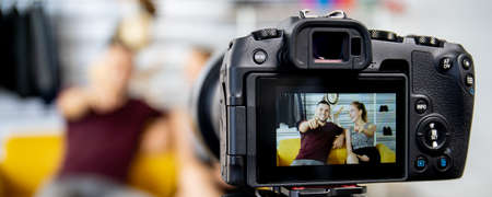 Two caucasian video blogger (Vlog) are live streaming their content and sharing through the internet. Happy couple talking in front of the camera and sharing their video on the social network.の写真素材