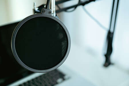 Modern wired headphone left on laptop computer with copyspace. Headphones on the personal notebook computer. Modern audio recording studio and online radio station. Audio live steaming equipment.の写真素材