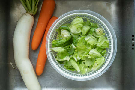 Various of organic vegetable in a washing basket in wash basin close up. Preparing a vegetable for...