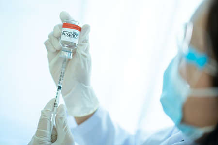 Beautiful Asian doctor wear a protective face shield and face mask while working in the hospital...