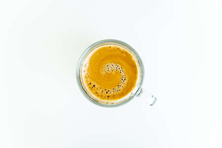 Beautiful texture on the surface of espresso crema in a cup on white table close up. Aromatic of Arabica medium dark roasted coffee brewed to espresso. Food and beverage photography in minimalist.の写真素材