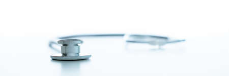 Professional medical stethoscope on the white table close up with copyspace. Doctor's stethoscope - headphones for listening heartbeat on white table background.の写真素材