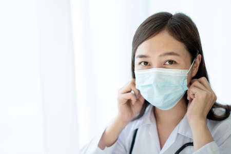 Asian female doctor using laptop computer for working in hospital. Doctor working with laptop - notebook computer in office in hospital. Health care worker and service.の写真素材