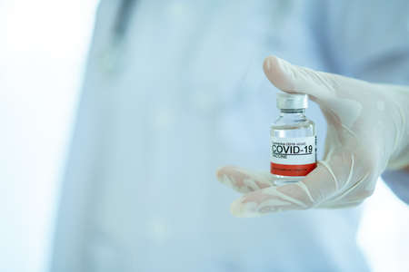 Doctor showing a COVID-19 or coronavirus vaccine on hand close up with copyspace. COVID-19 cure vaccine for injection use only. Doctor preparing a COVID 19 vaccine for injection to patient.の写真素材