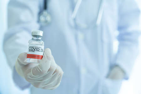 Doctor showing a COVID-19 or coronavirus vaccine on hand close up with copyspace. COVID-19 cure vaccine for injection use only. Doctor preparing a COVID 19 vaccine for injection to patient.の写真素材
