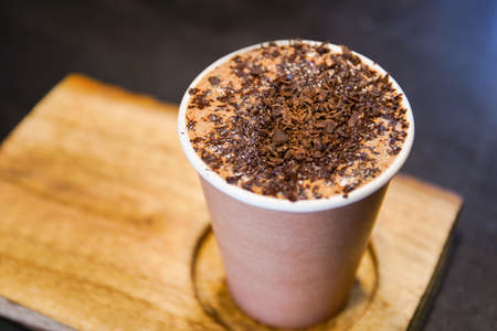 Specialty crafted hot chocolate beverage service on the wooden plate close up. A professional...