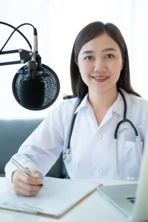 Asian doctor making an online video conference with her patient, tele medical service concept. Female doctor making a medication advise via online podcast.の写真素材