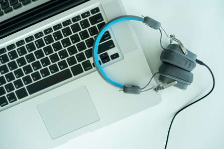 Modern wired headphone left on laptop computer with copyspace. Headphones on the personal notebook computer. Relaxation after working.の写真素材