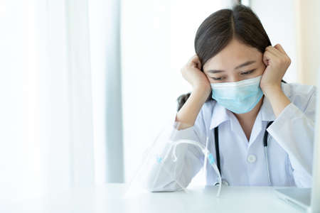 Hard working of Asian young female doctor in hospital, stressful - workaholic health care worker in hospital. Medication working tired from hard working.の写真素材