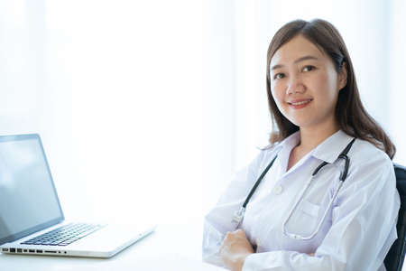 Beautiful Asian female doctor portrait in doctor office in hospital close up with copyspace. Health care worker or health care service staff in hospital. Medication officer working concept.の写真素材
