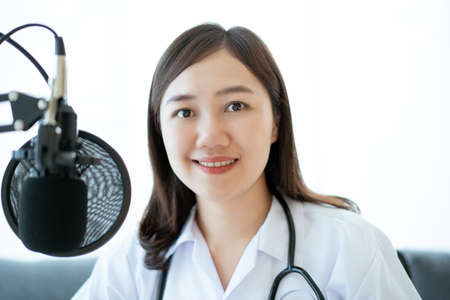Asian doctor making an online video conference with her patient, tele medical service concept. Female doctor making a medication advise via online podcast.の写真素材