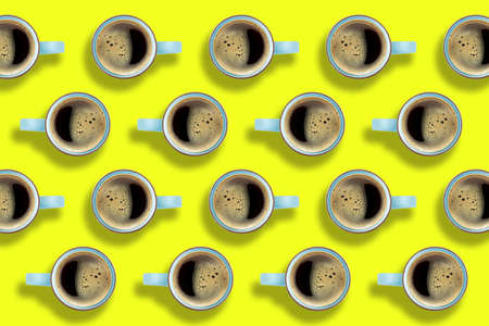 Pattern of coffee cups on bright yellow background. A hot Americano coffee in a cups arranged on yellow background.の写真素材