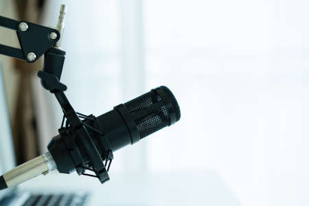 Professional condenser microphone on a microphone holder close up with copyspace. Live podcast and streaming concept at home.の写真素材