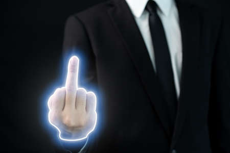 Unrecognizable businessman in smart casual showing a middle finger, the middle finger with the illuminated neon effect close up. Impolite man showing a middle finger.の写真素材