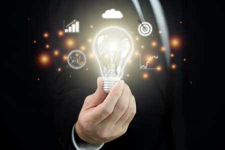 Unrecognizable smart businessman showing an illuminated lightbulb on hand close up with copyspace....