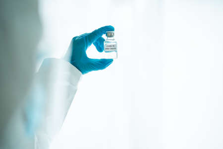 Unrecognizable specialist doctor in a medical PPE suit showing a coronavirus SARS 2019-nCoV or COVID-19 mRNA vaccine. Personal Protection Equipment or PPE suit use for coronavirus - COVID-19 pandemic.の写真素材
