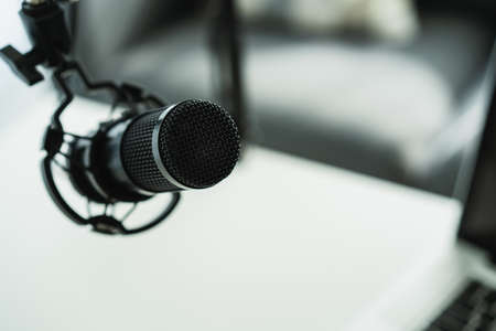 Professional condenser microphone on a microphone holder close up with copyspace. Live podcast and streaming concept at home.の写真素材