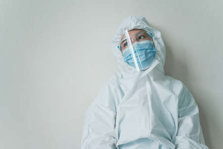 Stressful - worried Asian medication staff sitting on a chair against the wall, healthcare worker...