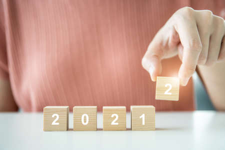 Step up on wood blocks ladder placed the word 2022 for 2022 new year celebration, unrecognizable...